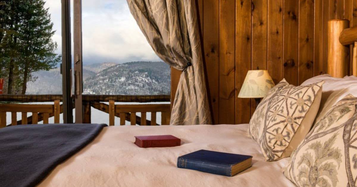 hotel bed overlooking snowy mountains