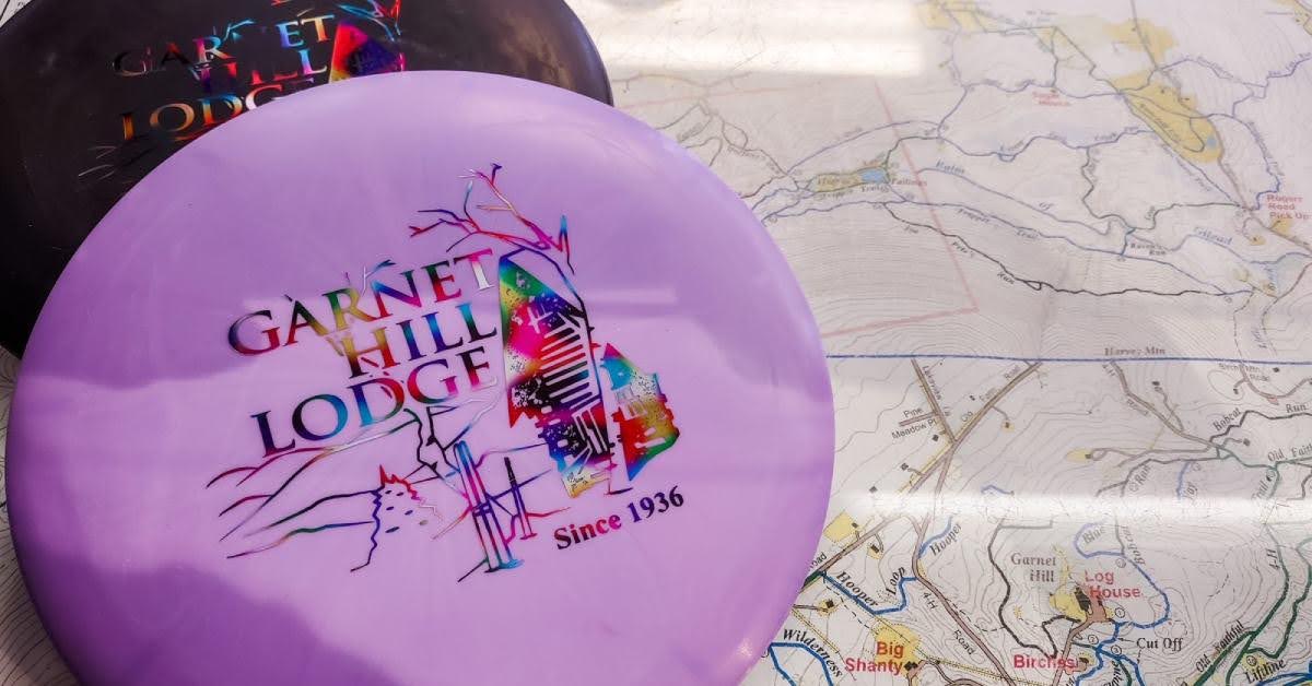 purple disc with garnet hill lodge logo on it
