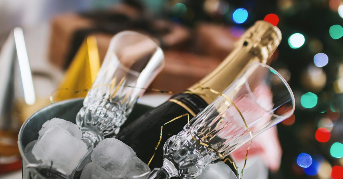 bottle of champagne and two glasses in an ice bucket