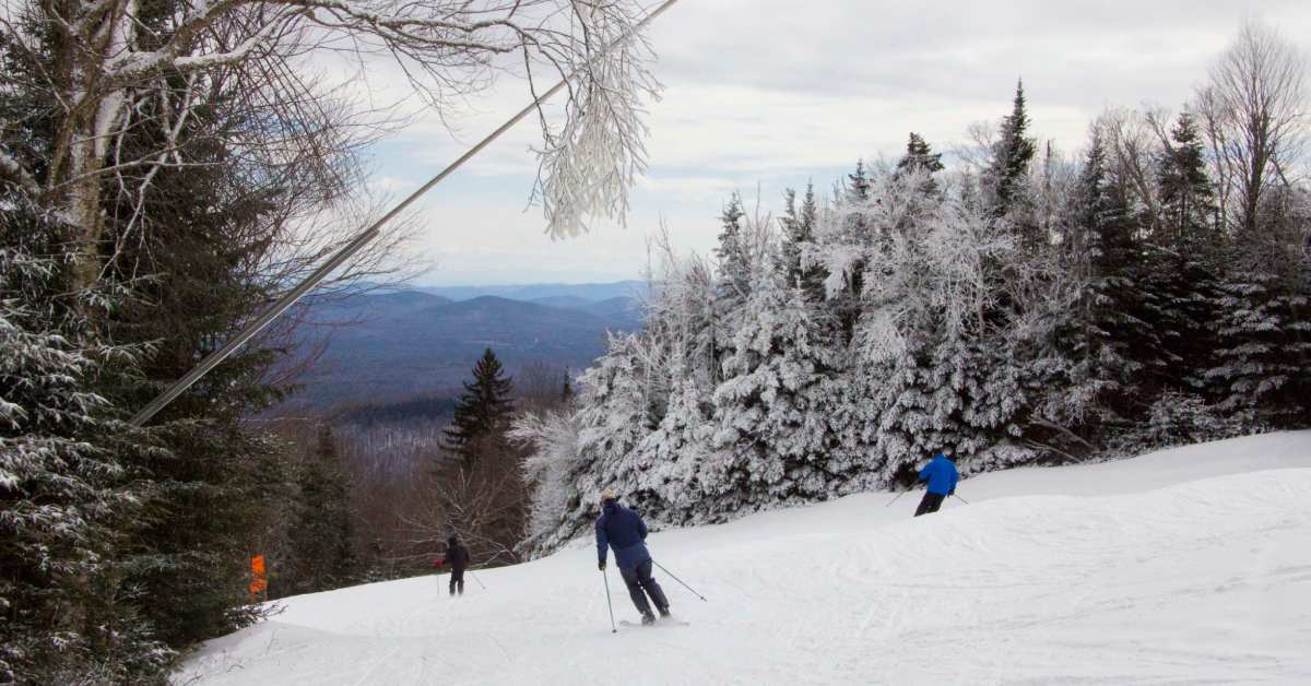 three people downhill skiing