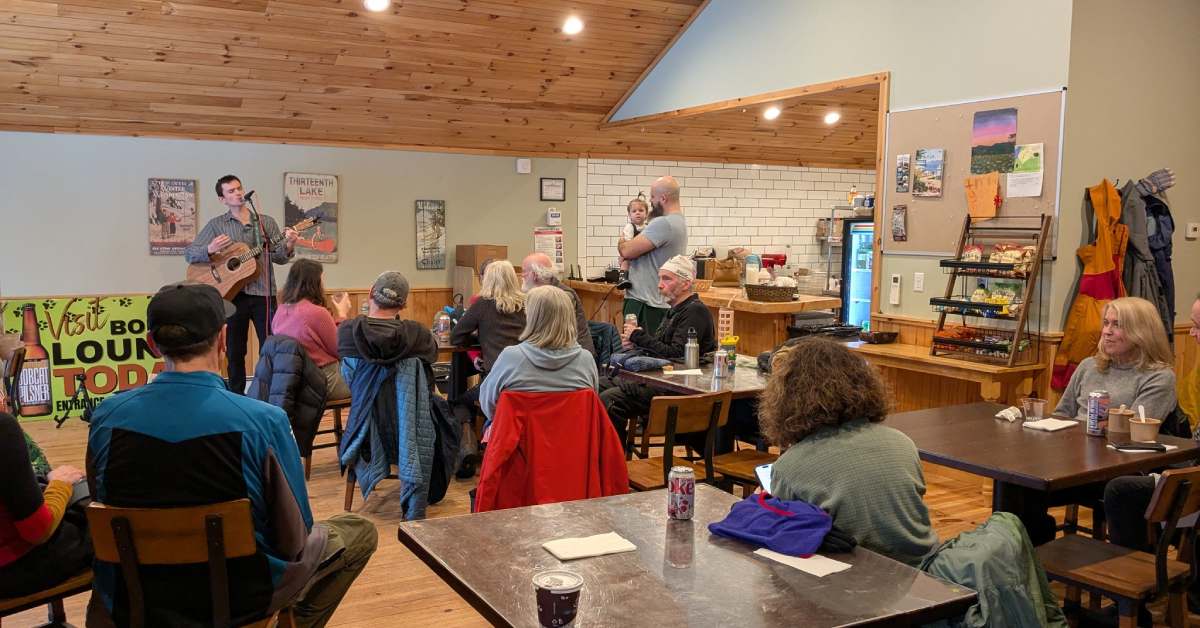 group of people sitting in a restaurant watching a performer