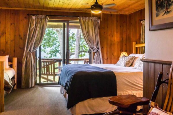 rustic bedroom with bed and view of the outdoors from balcony