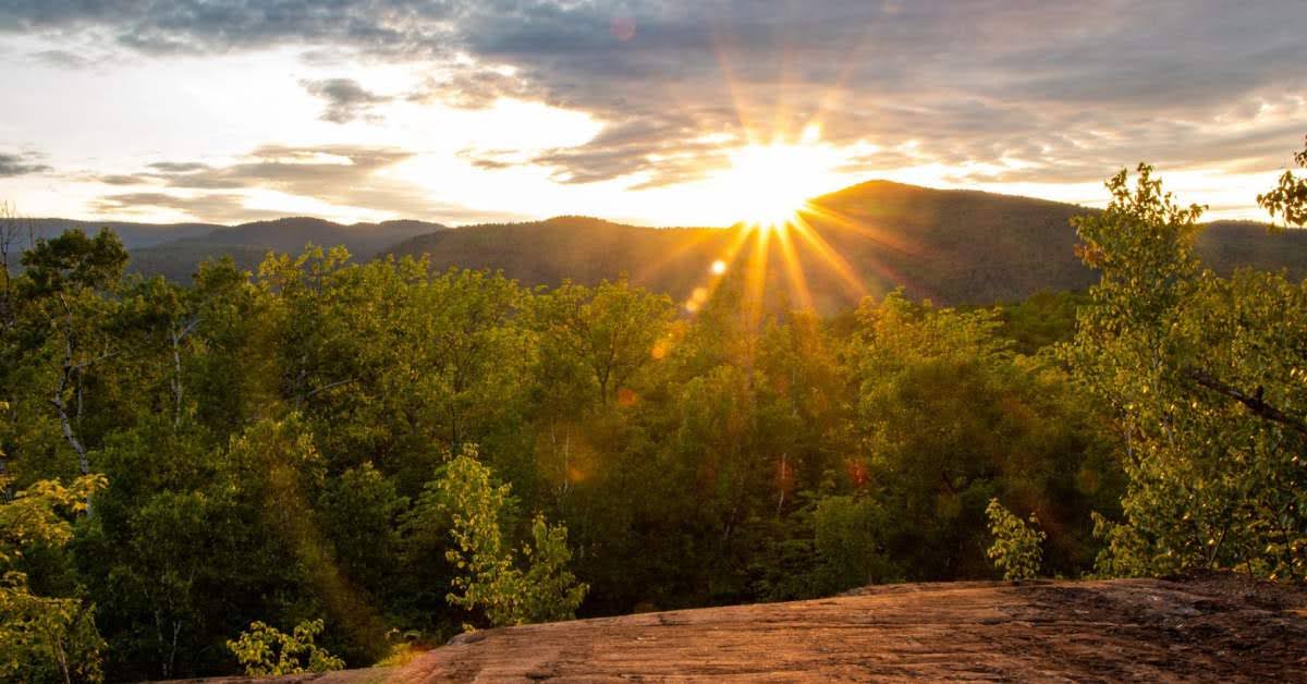 view of the sun going behind mountains