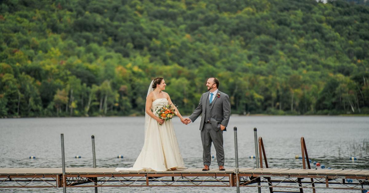 newlyweds holding hands on a dock