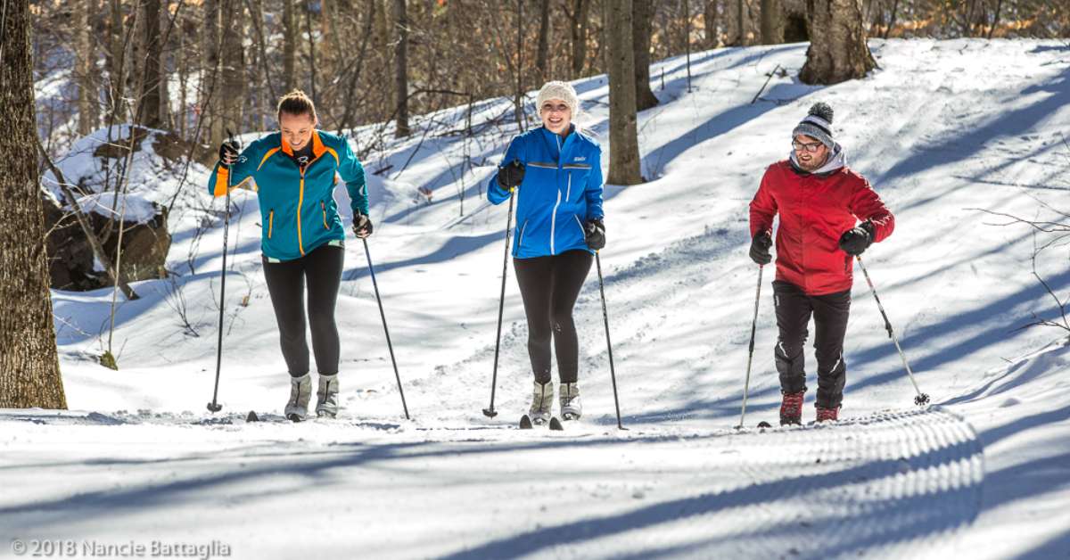 three women in colorful jackets cross country skiing